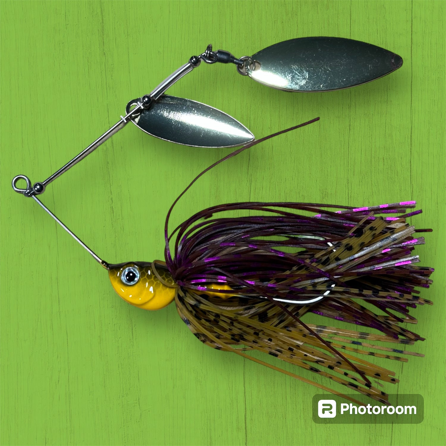 A spinner bait fishing lure with silver blades and a purple and black brown skirt. Murray cod