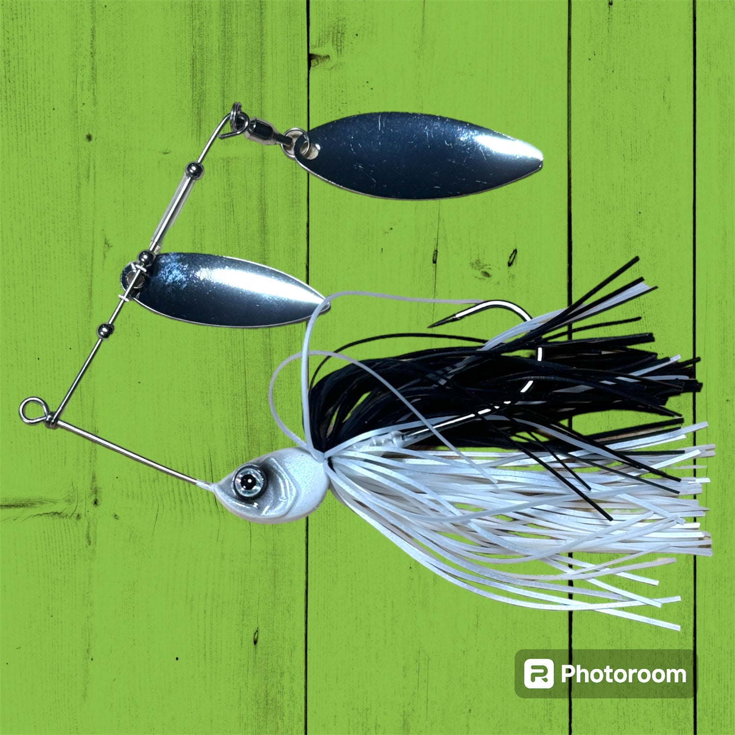 A spinner bait fishing lure with silver blades and a white and black skirt.
