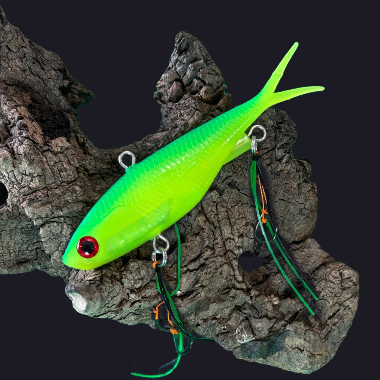 A multicoloured fishing lure with a vibrating tail designed to imitate the movement of fish, equipped with two sets of stinger hooks.