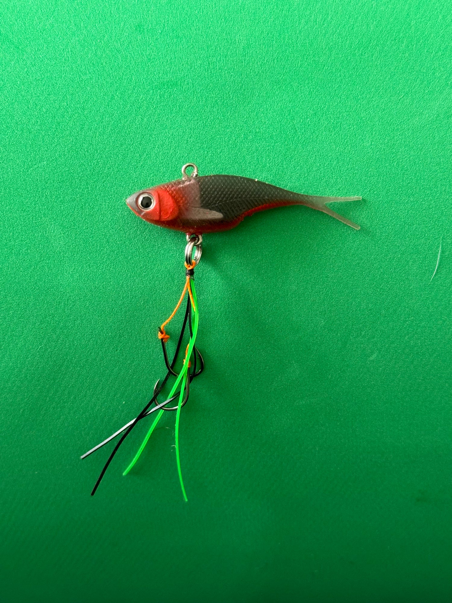 A black and red coloured fishing lure named 'Shammy Vibes' soft vibe 55mm yellow belly assist hooks
