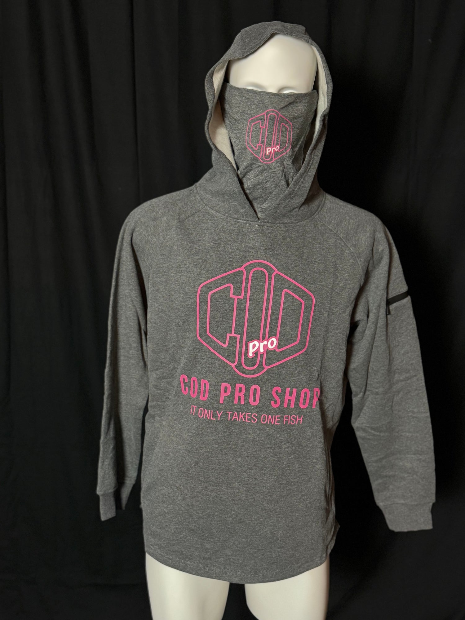 A grey hoodie with the text 'COD PRO SHOP' displayed prominently, featuring a hood and a built-in neck scarf. The hoodie is presented on a mannequin against a black background.