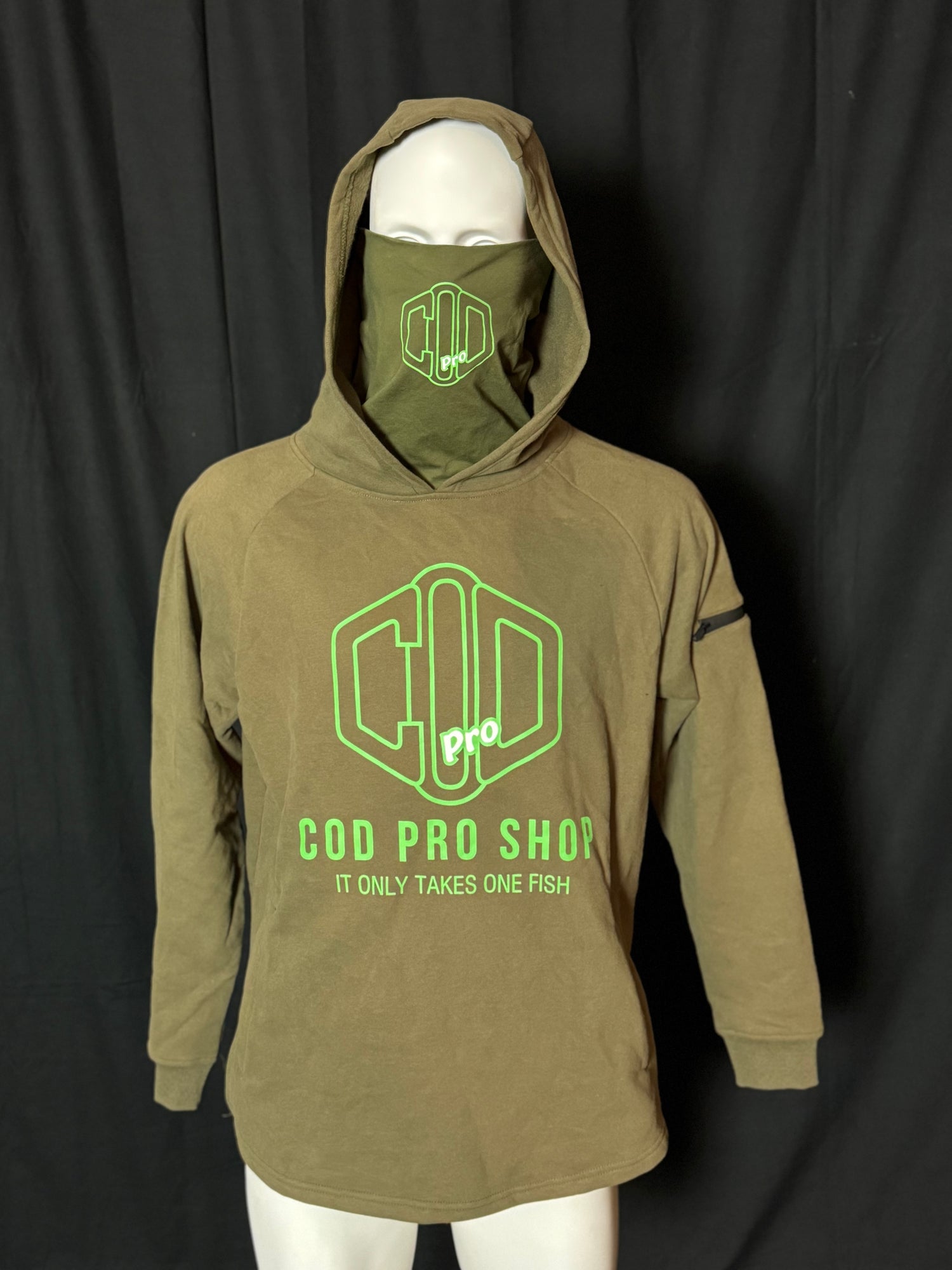 A green hoodie with the text 'COD PRO SHOP' displayed prominently, featuring a hood and a built-in neck scarf. The hoodie is presented on a mannequin against a black background.