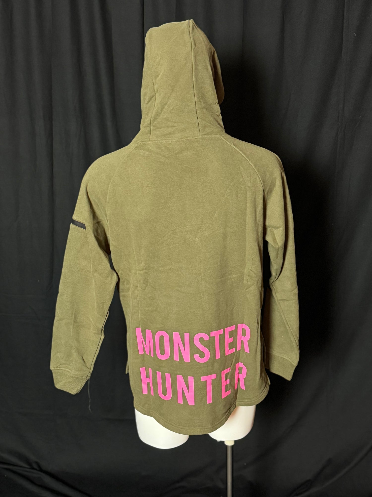 A green hoodie with the text 'COD PRO SHOP' displayed prominently, featuring a hood and a built-in neck scarf. The hoodie is presented on a mannequin against a black background.