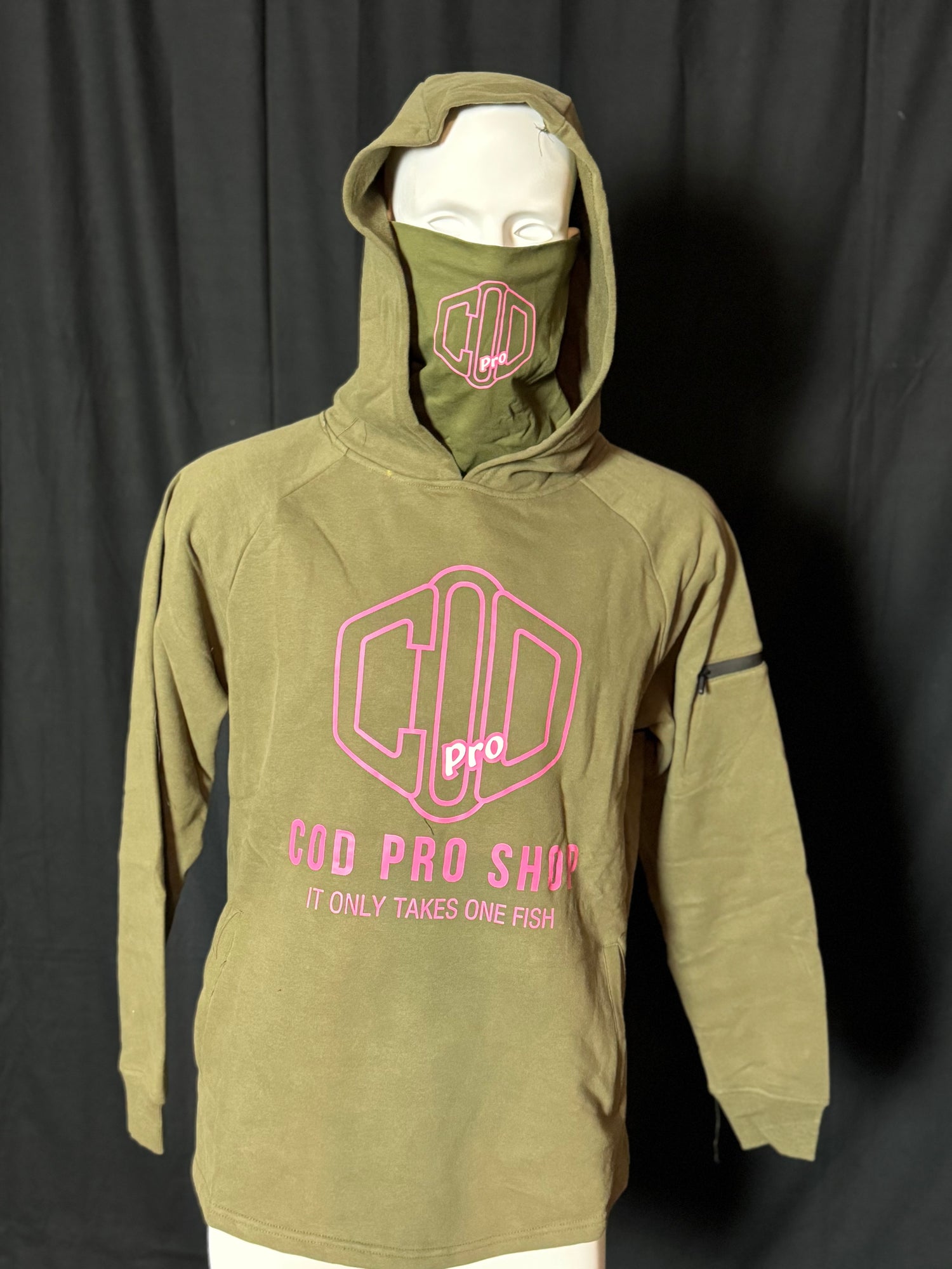 A green hoodie with the text 'COD PRO SHOP' displayed prominently, featuring a hood and a built-in neck scarf. The hoodie is presented on a mannequin against a black background.
