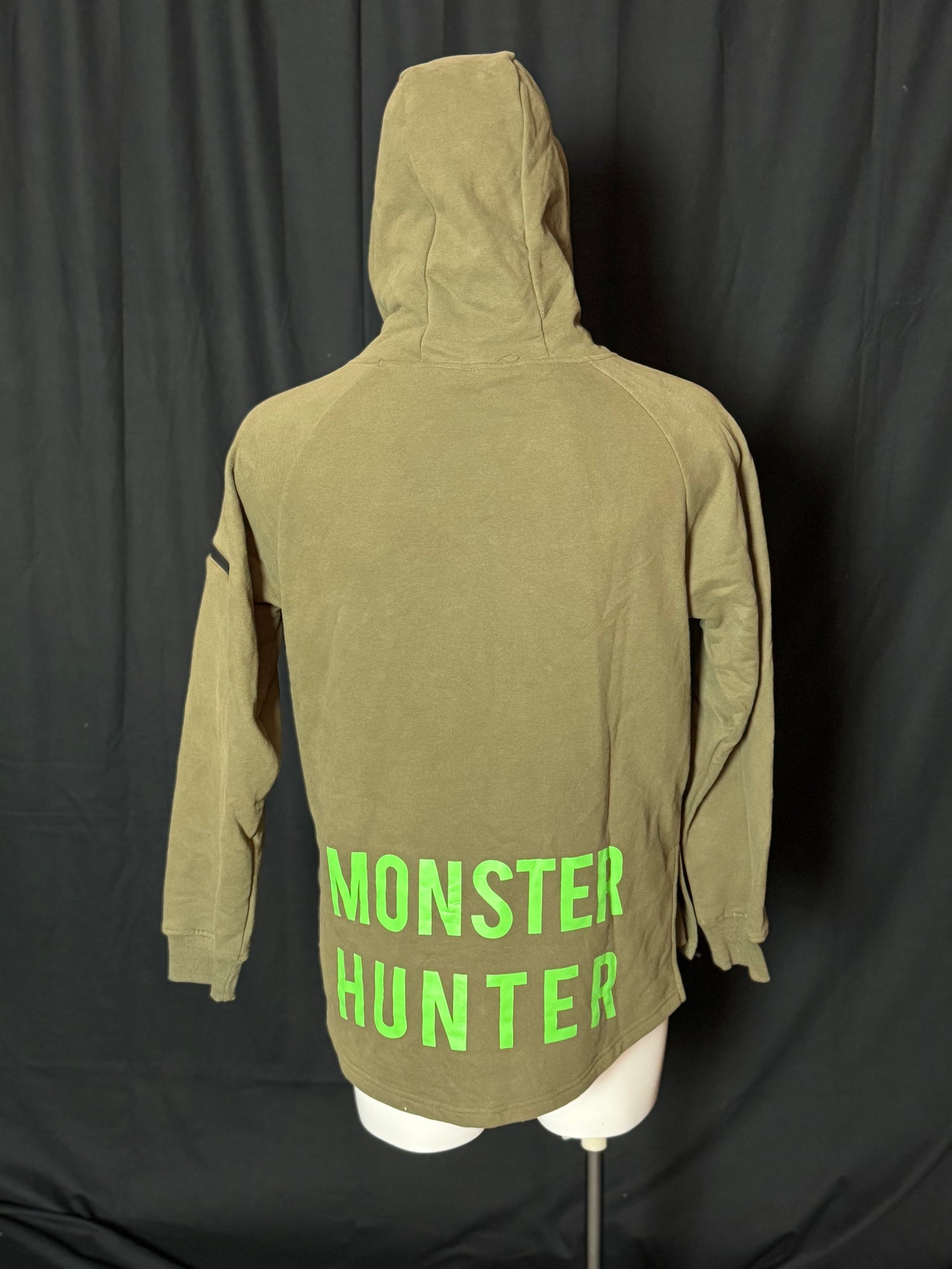 A green hoodie with the text 'COD PRO SHOP' displayed prominently, featuring a hood and a built-in neck scarf. The hoodie is presented on a mannequin against a black background.