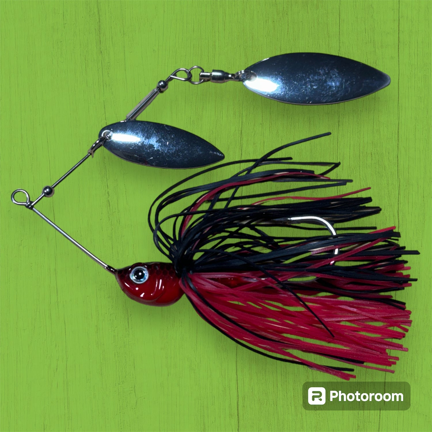 A spinner bait fishing lure with silver blades and a red and black skirt. Murray cod